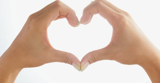A pair of women's hands forming the shape of a heart