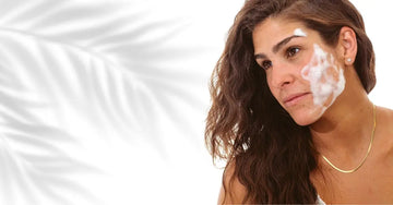 A photo of a woman with Simple Body Foaming Facial Cleanser on her face with long auburn hair and a plant shadow in the background.