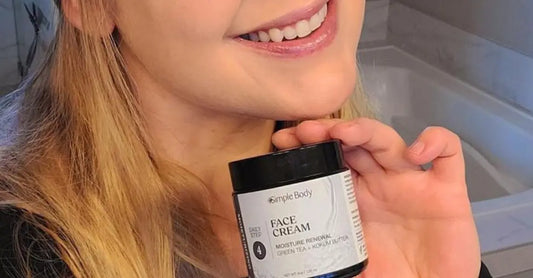 A close-up image of our customer Danica holding a 4oz Simple Body Face Cream and smiling big.