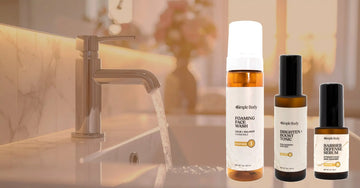 A photo of Simple Body products including Foaming Face Wash in Chamomile, Brighten + Boost, and Barrier Defense Serum on a blurred background of a bathroom sink.