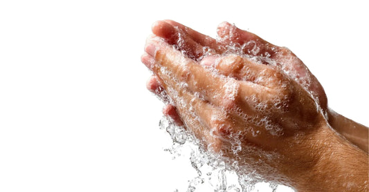 A photo of two hands washing and water splashing with a white background