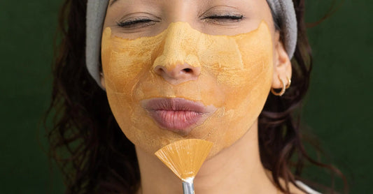 A woman in her 30s doing her skincare routine with a Simple Body Caramel Clay Mask