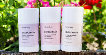 A photo of three Simple Body All-Natural Deodorants including Lavender, Himalayan Magic, and Citrus Burst in front of a vibrant bush with flowers.