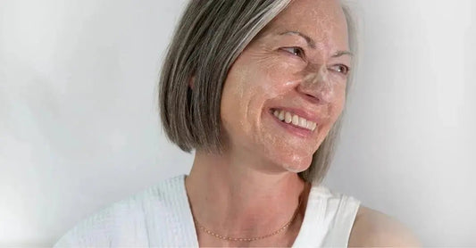 A side profile photo of Michele, a Simple Body Customer, smiling with Bamboo Face Polish on her skin.