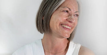 A side profile photo of Michele, a Simple Body Customer, smiling with Bamboo Face Polish on her skin.
