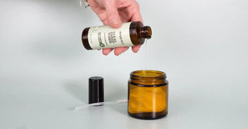 A photo of Jewels Burdick, Founder of Simple Body's hand pouring Clean Sweep Toner into a jar containing white cotton pads.