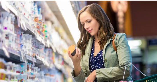 A young woman in a grocery store aisle shops skincare and tries to avoid greenwashing.