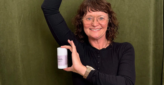 Simple Body Founder, Jewels Burdick, holds up a stick of Baking Soda Free, Sensitive Skin Natural Deodorant with a purple label