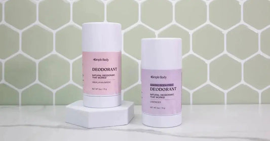 A photo of The Best Natural Deodorant Simple Body All-Natural Deodorant including Himalayan Magic and Baking Soda Free Lavender sitting in front of a mint green tile wall.