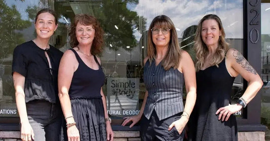 A photo of the Simple Body team standing in front of the store window dressed in all black outfits.