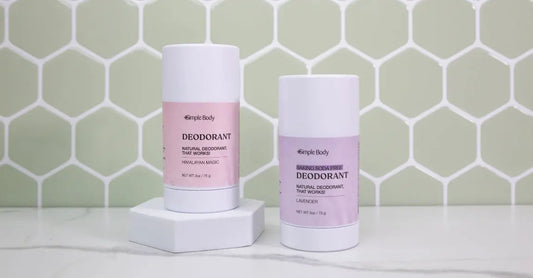A photo of The Best Natural Deodorant Simple Body All-Natural Deodorant including Himalayan Magic and Baking Soda Free Lavender sitting in front of a mint green tile wall.