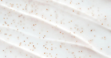 A very close up image of Simple Body Bamboo Face Polish with the texture very visible, but in a creamy white lotion.