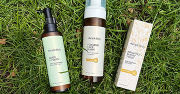 A photo of Simple Body Products laying in the green grass including Rosemary Mint Body Lotion, Chamomile Foaming Face Wash, and Brighten and Boost Skincare Tonic
