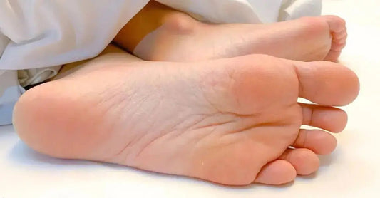 A close up photo of the bottom of a persons feet that look smooth, soft and hydrated.