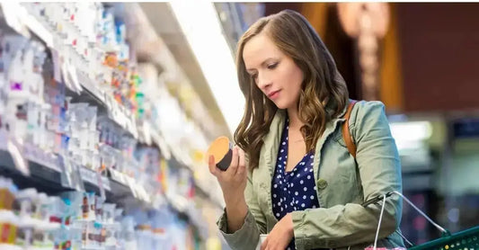 A young woman in a grocery store aisle shops skincare and tries to avoid greenwashing.