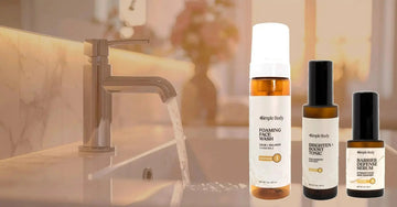 A photo of Simple Body products including Foaming Face Wash in Chamomile, Brighten + Boost, and Barrier Defense Serum on a blurred background of a bathroom sink.