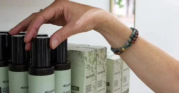 A photo of Jewels Burdick, our founder with her hand reaching for a Clean Sweep Toner.
