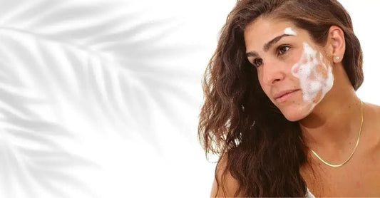 A photo of a woman with Simple Body Foaming Facial Cleanser on her face with long auburn hair and a plant shadow in the background.
