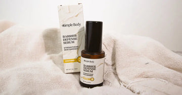A photo of Simple Body Barrier Defense Serum sitting on a beige cloth.