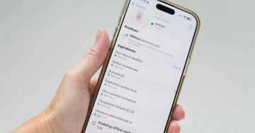 Hand holding a smartphone displaying Yuka, an ingredient rating app, used to scan Simple Body Natural Deodorant skincare product ingredients and showing a perfect score of 100/100.