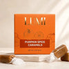 LUMI Pumpkin Spice Caramels in an orange box with gold lettering, styled with unwrapped caramel candies on a light stone surface.