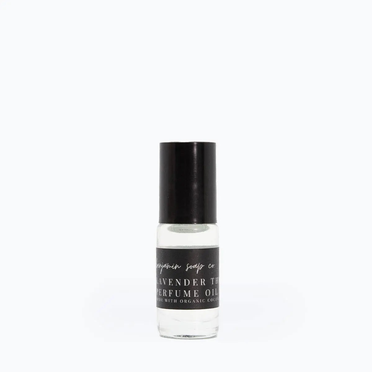 Perfume oil bottle with black cap and label on a white background