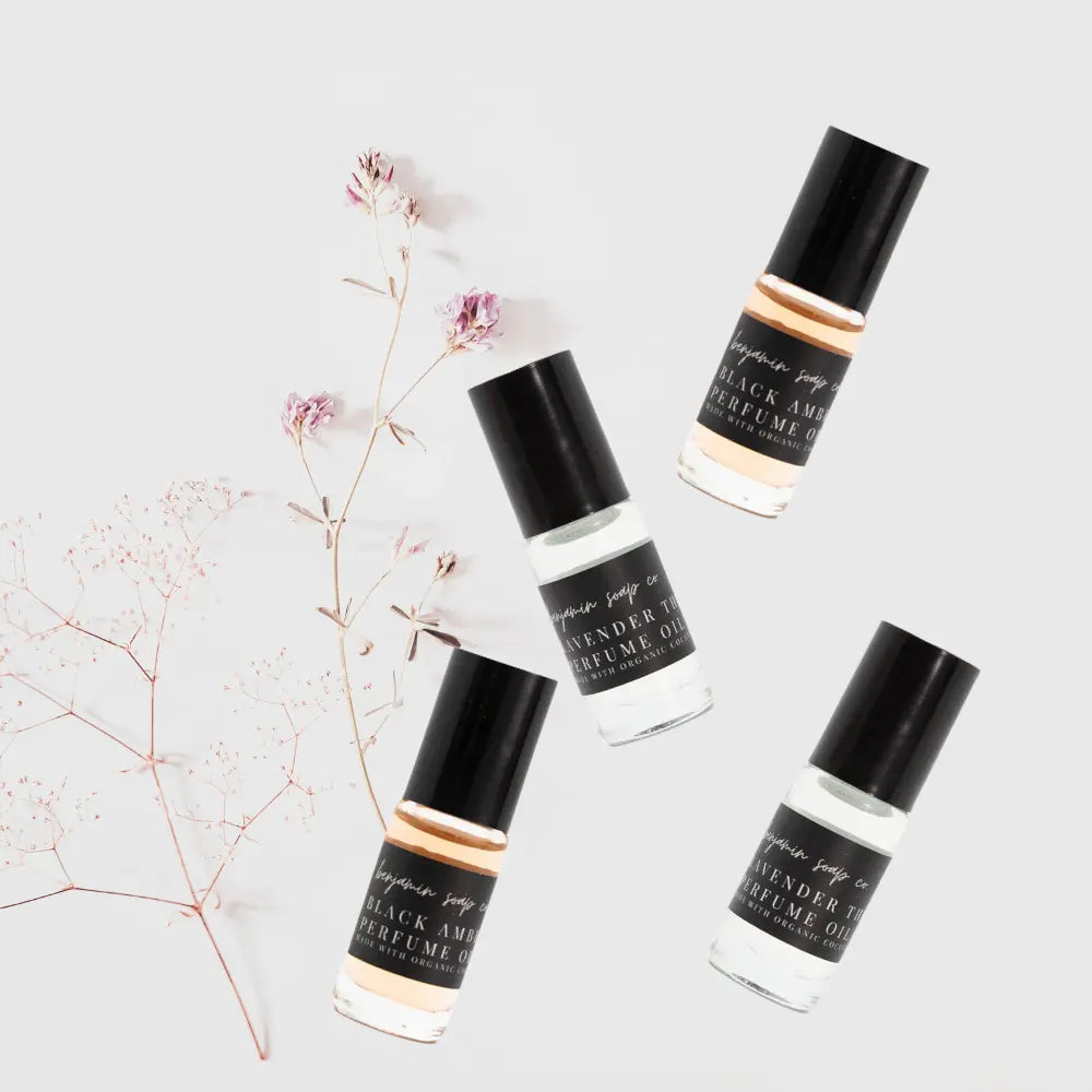 Four perfume bottles with black and white labels on a light gray background