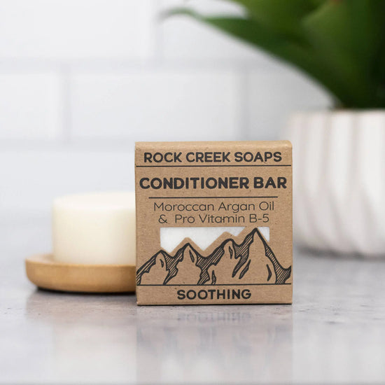 Rock Creek Soaps conditioner bar on a countertop with a blurred background