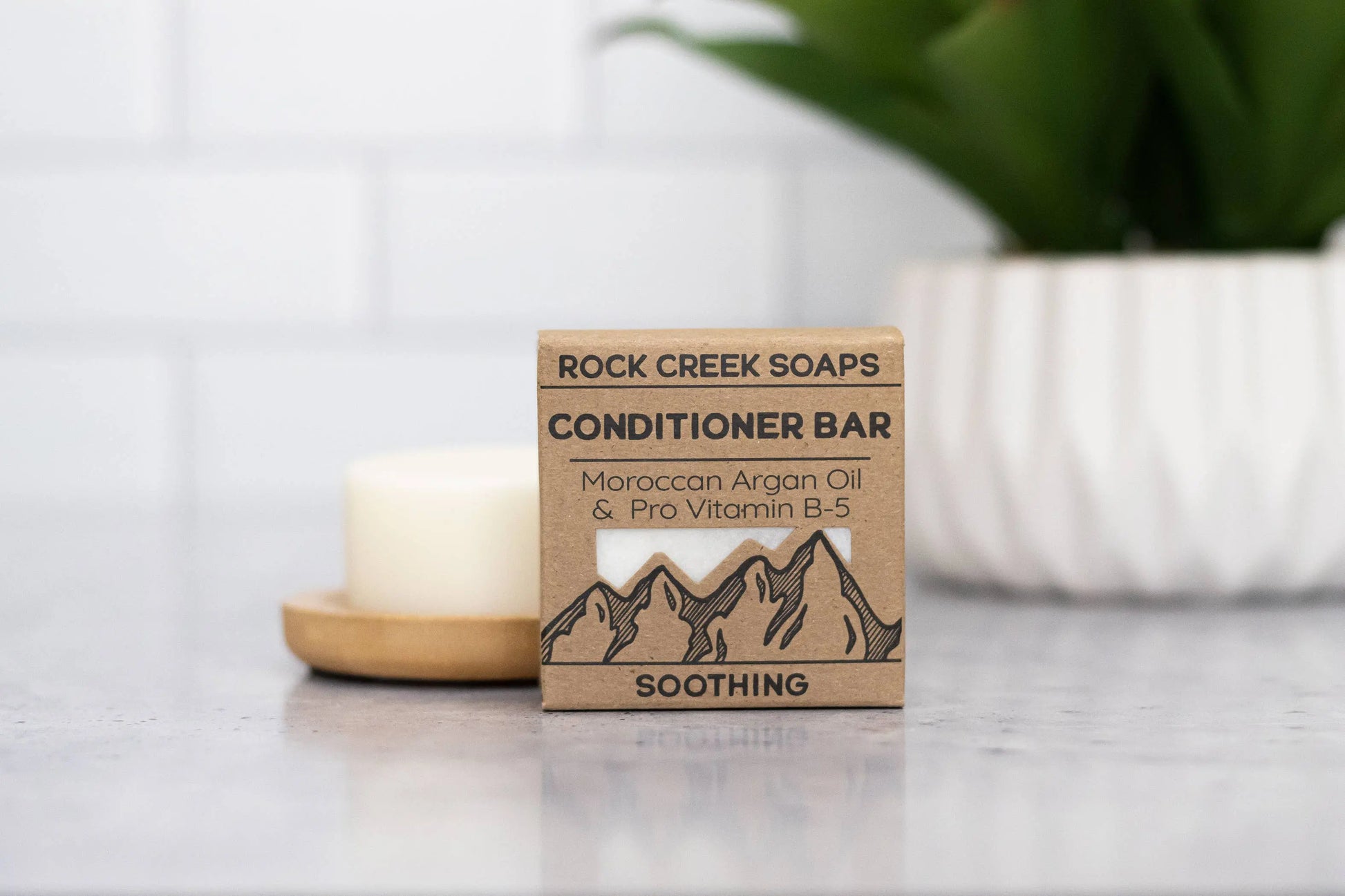 Rock Creek Soaps conditioner bar on a countertop with a blurred background