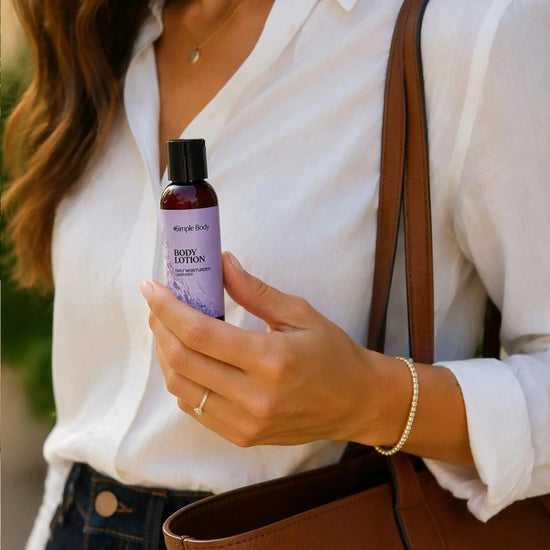 Woman holding a Simple Body 2.5oz Travel Body Lotion Bottle with a brown leather bag