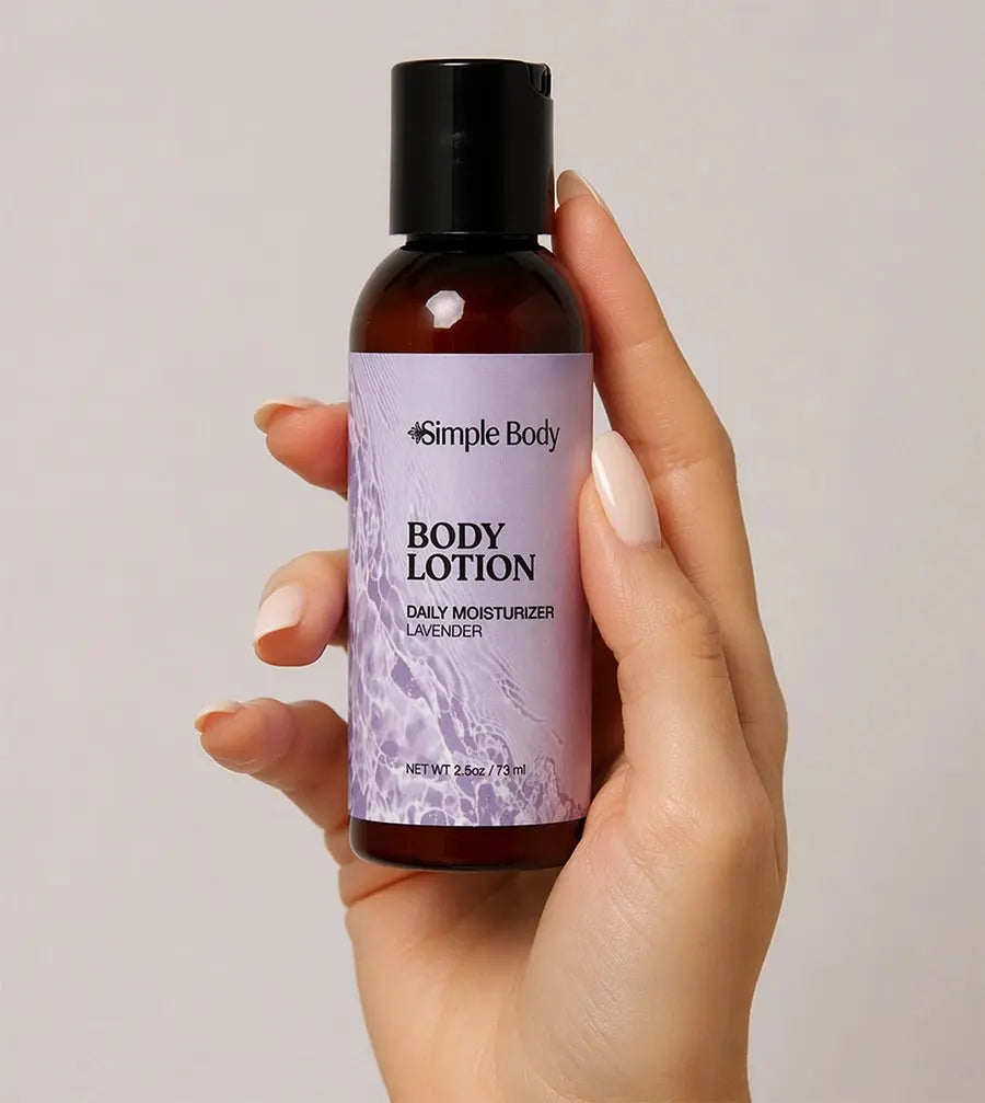 Hand holding a bottle of Simple Body Lavender Travel-Sized Body Lotion against a neutral background