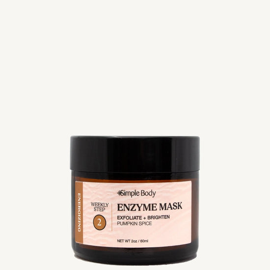 A black and clear glass jar with a label that reads 'Enzyme Mask' and indicates the product is for exfoliating and brightening the skin. The jar is set against a white background.