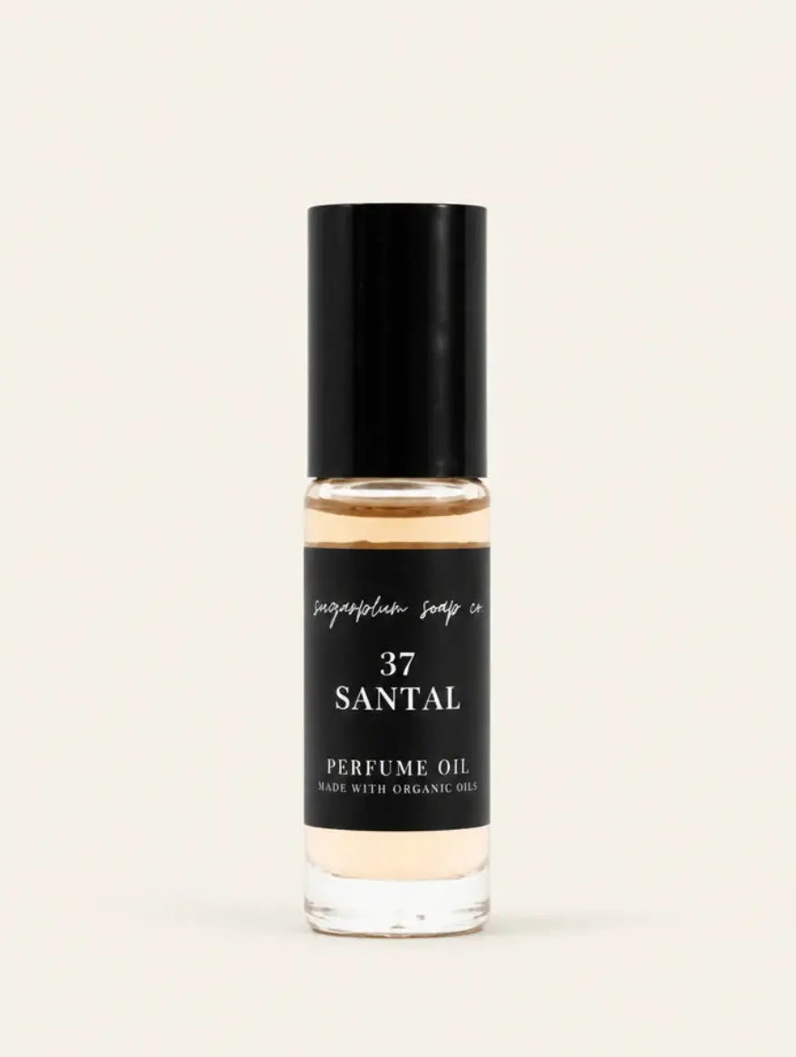 A clear glass bottle of Santal 37 perfume oil from Benjamin Soap Cowith a black cap and a black label, set against a solid off-white background.