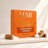 LUMI Pumpkin Spice Caramels in an orange box, styled on a marble surface with two wrapped caramels in the foreground and background.