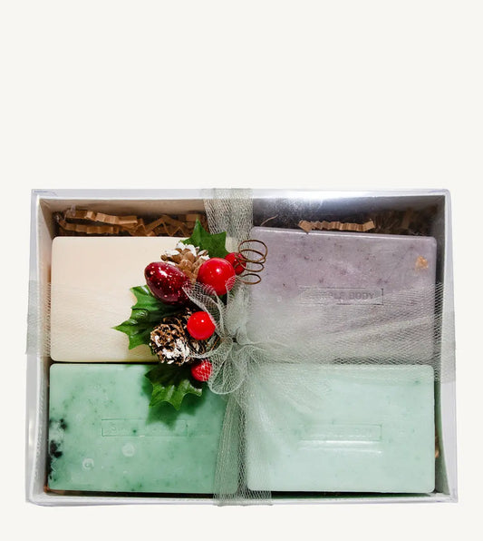 Set of Simple Body handmade soaps including Himalayan Magic Soap, Breathe Better Eucalyptus soap, Lemongrass soap, and Rosemary Mint Soap with decorative elements in a box on a white background