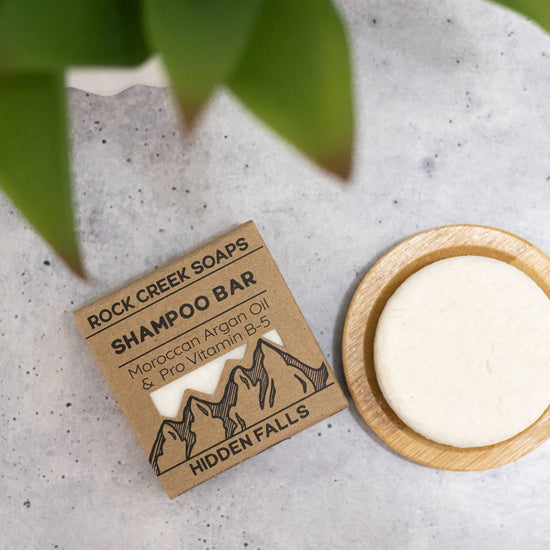 Shampoo bar from Rock Creek Soaps with packaging on a concrete surface