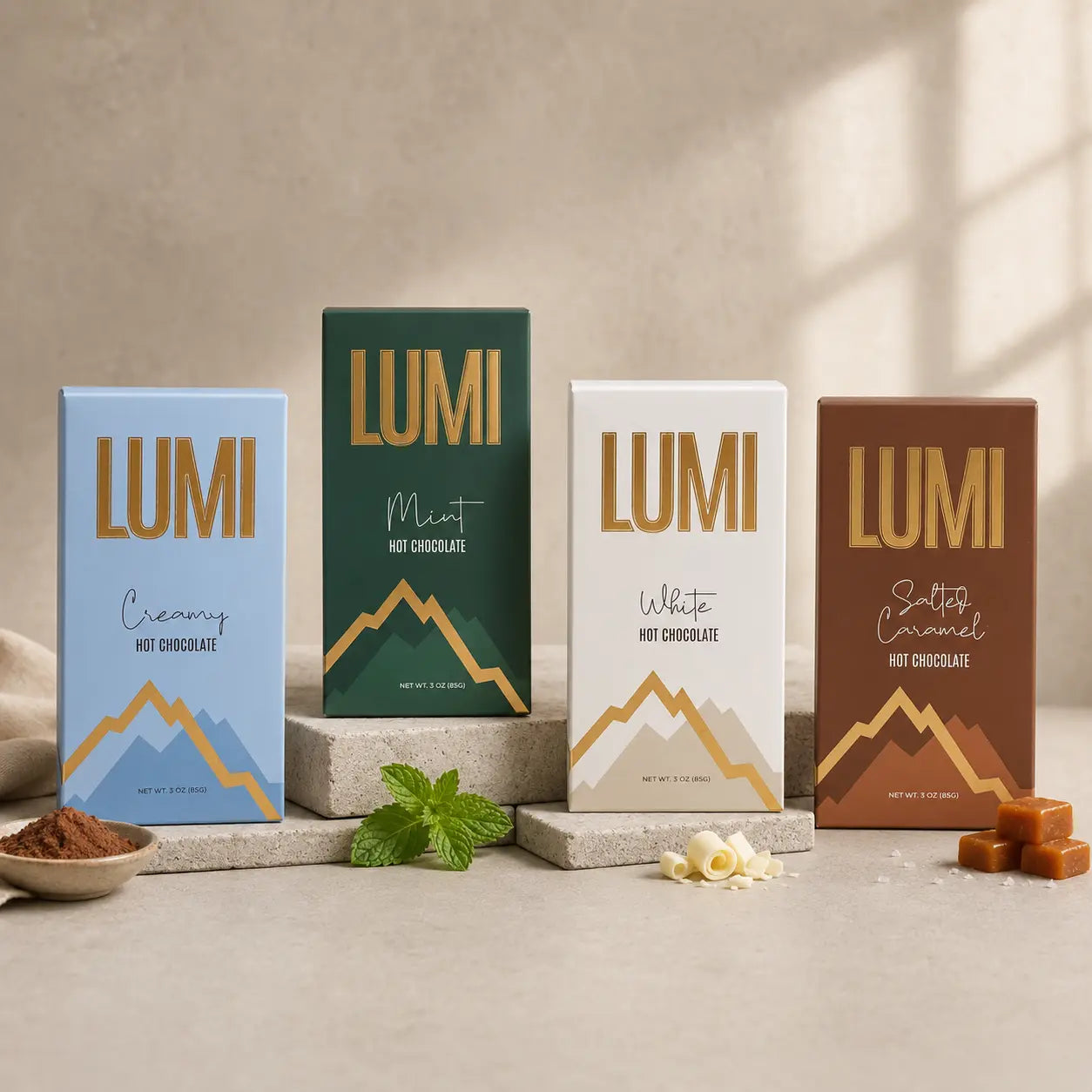 Four LUMI hot chocolate packaging boxes on a neutral background with a bowl of cacao powder and mint leaves.