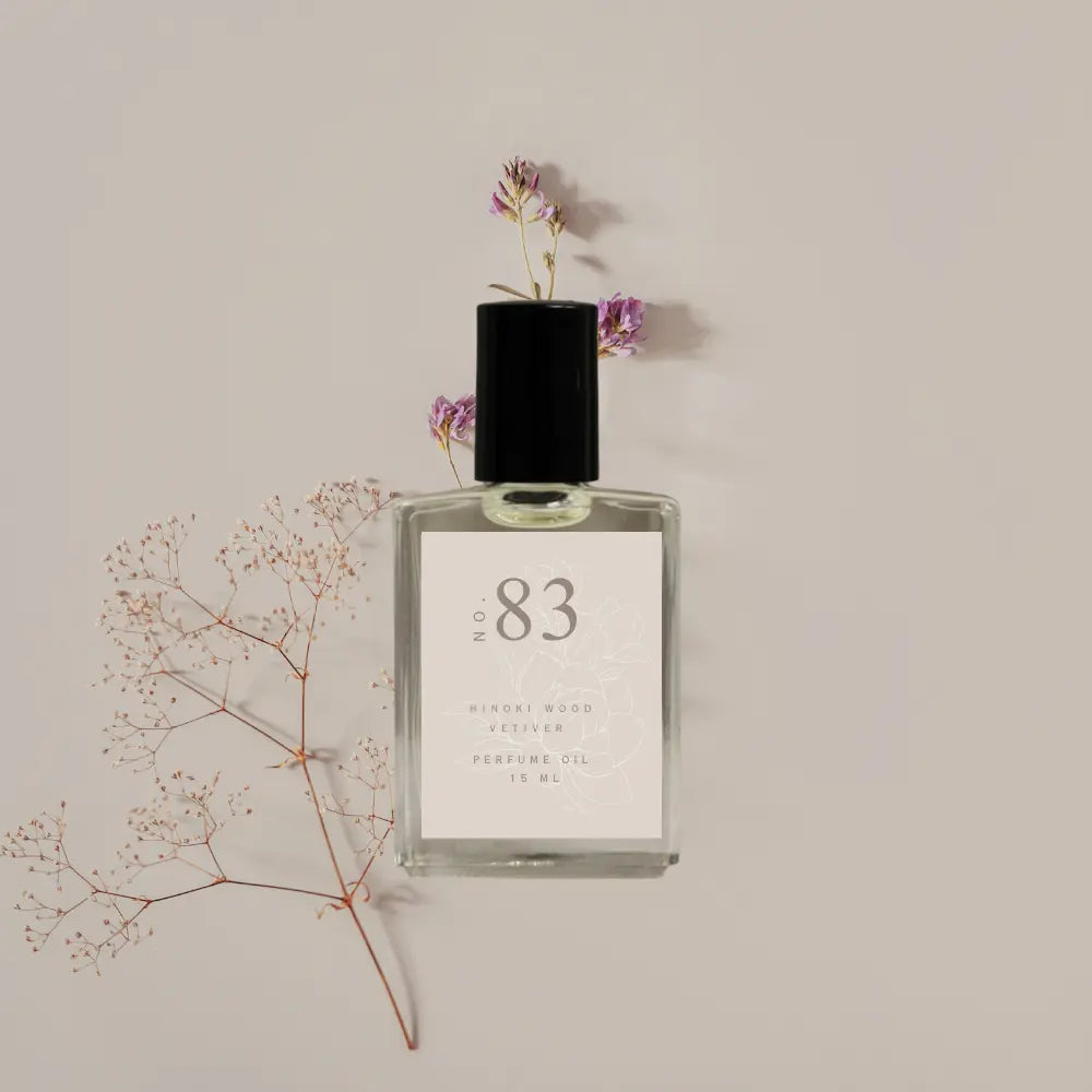Perfume bottle labeled 'No. 83' with flowers on a beige background