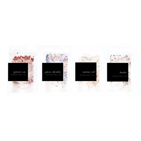 Four small containers with decorative labels on a white background