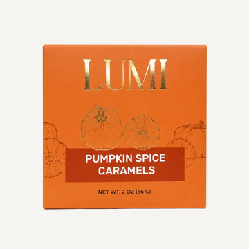 LUMI Pumpkin Spice Caramels packaging box in orange with gold foil lettering and pumpkin illustrations, shown on a white background.