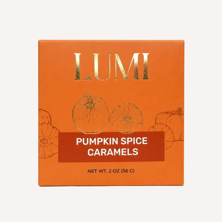LUMI Pumpkin Spice Caramels packaging box in orange with gold foil lettering and pumpkin illustrations, shown on a white background.