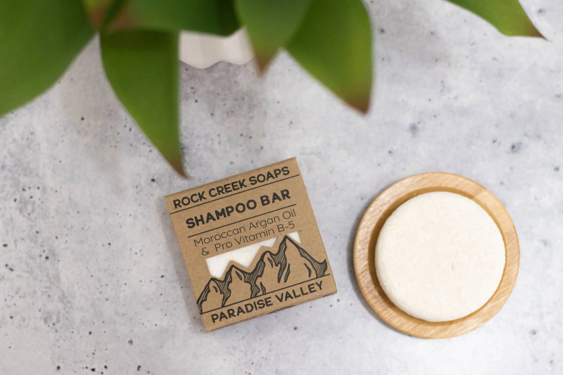 Rock Creek Soaps shampoo bar with packaging on a concrete surface