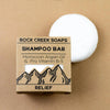 Rock Creek Soaps shampoo bar with packaging on a beige background