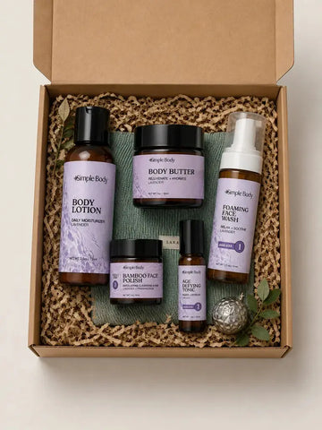 A gift box with a Simple Body Travel Lotion, Body Butter, Bamboo Face Polish, Age Defying Tonic and Foaming Face Wash on top of a green corduroy Cosmetic Bag.