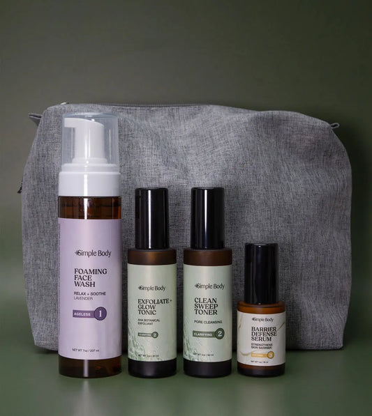 An Acne Skincare Kit that includes a Foaming Face Wash, Exfoliate and Glow Botanical Exfoliant, Clean Sweep Toner, Barrier Defense Serum and a gray cosmetic bag with a green background