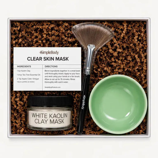 A Simple Body Clay Mask Kit with a White Kaolin Clay Mask, Green Bowl, Fan Brush and recipe card with kraft crinkle paper in a gift box.