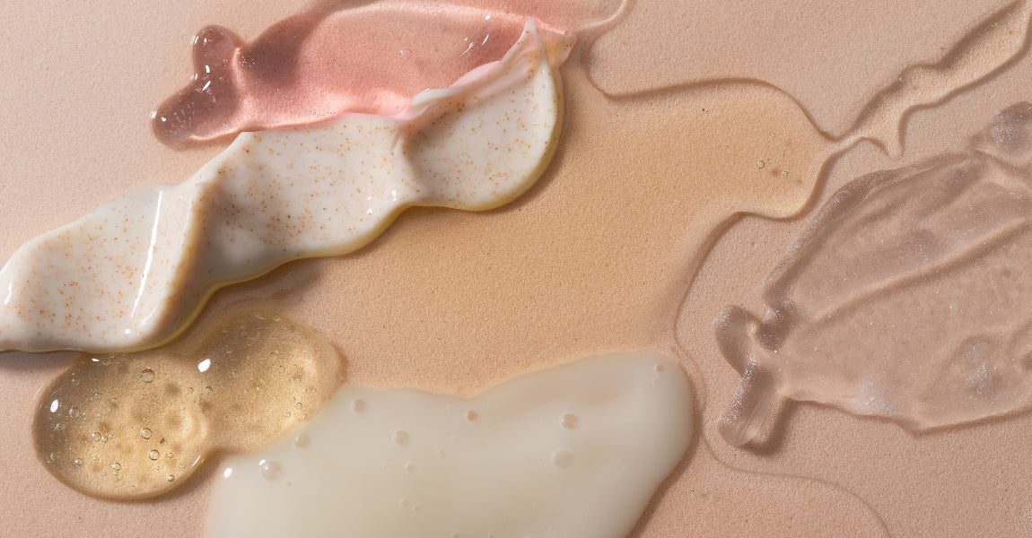 Close-up of different colored cosmetic liquids on a beige background
