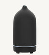 A modern ceramic essential oil diffuser in black against a white background.