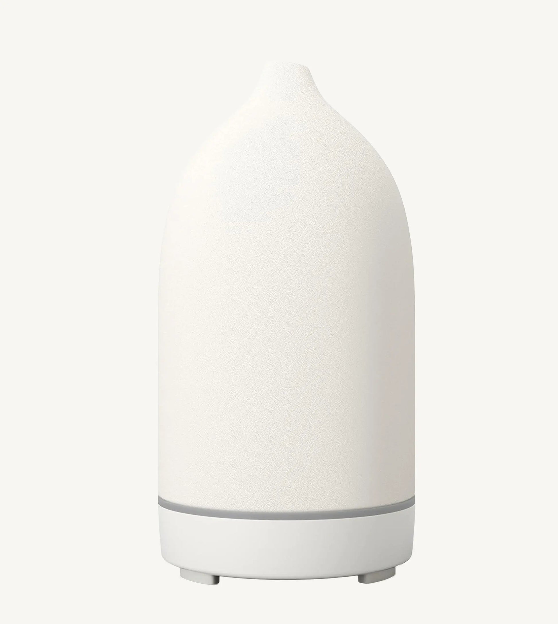 A modern ceramic essential oil diffuser in white against a white background.