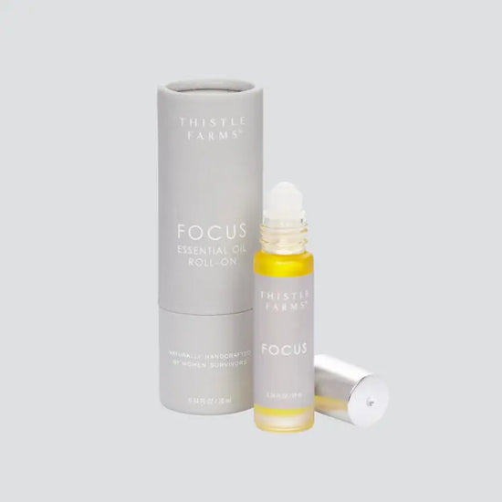 Thistle Farms Focus essential oil roll-on bottle and packaging on a light gray background
